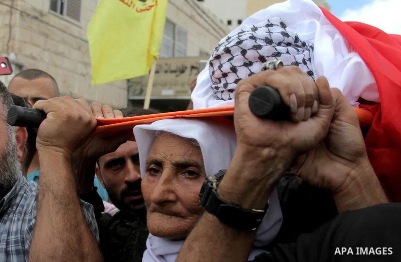 The mother of Palestinian Yassir Hamduni carries his body during the funeral in the west bank village of Yabad, near Jenin City, on September 27, 2016. Hamduni died of a heart condition in Israeli prison on Sunday after...