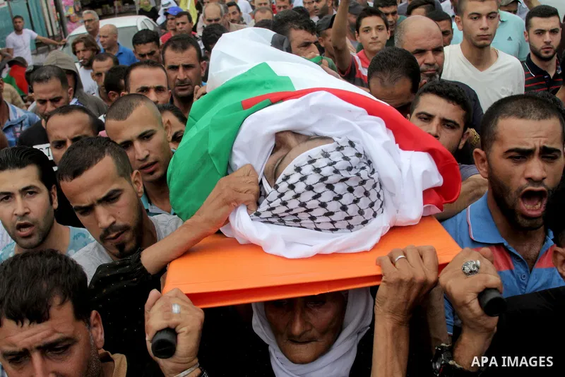 The mother of Palestinian Yassir Hamduni carries his body during the funeral in the west bank village of Yabad, near Jenin City, on September 27, 2016. Hamduni died of a heart condition in Israeli prison on Sunday after...
