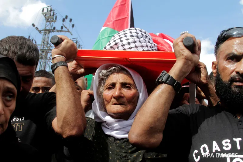The mother of Palestinian Yassir Hamduni carries his body during the funeral in the west bank village of Yabad, near Jenin City, on September 27, 2016. Hamduni died of a heart condition in Israeli prison on Sunday after...