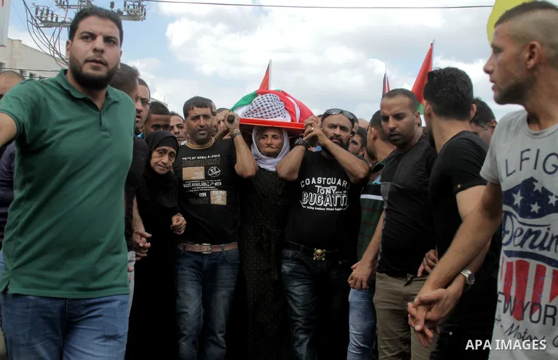 The mother of Palestinian Yassir Hamduni carries his body during the funeral in the west bank village of Yabad, near Jenin City, on September 27, 2016. Hamduni died of a heart condition in Israeli prison on Sunday after...