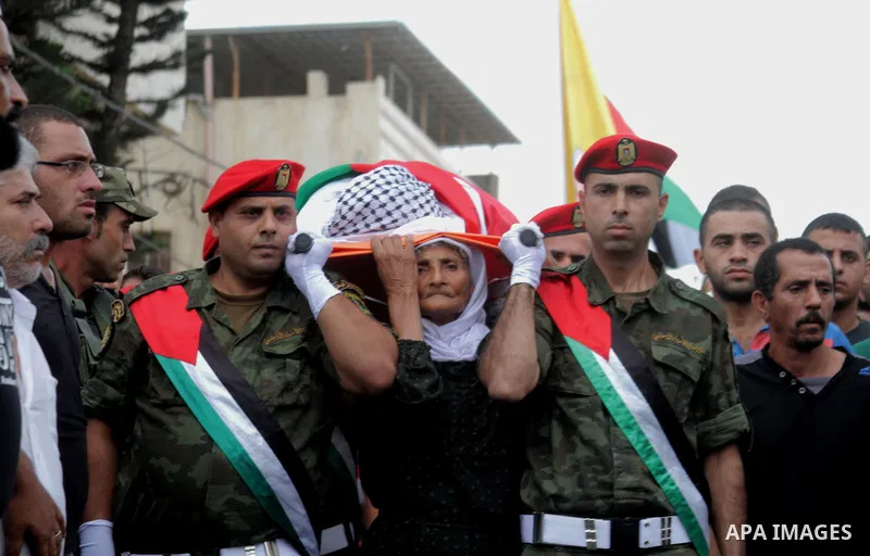 The mother of Palestinian Yassir Hamduni carries his body during the funeral in the west bank village of Yabad, near Jenin City, on September 27, 2016. Hamduni died of a heart condition in Israeli prison on Sunday after...