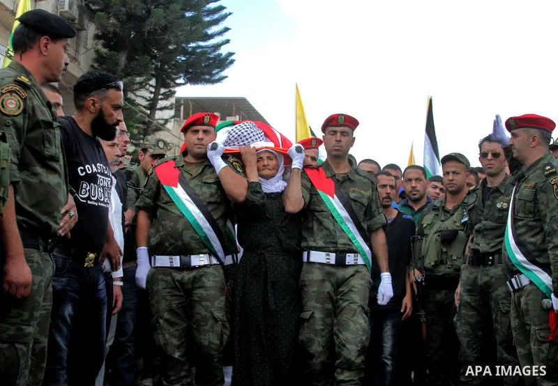 The mother of Palestinian Yassir Hamduni carries his body during the funeral in the west bank village of Yabad, near Jenin City, on September 27, 2016. Hamduni died of a heart condition in Israeli prison on Sunday after...