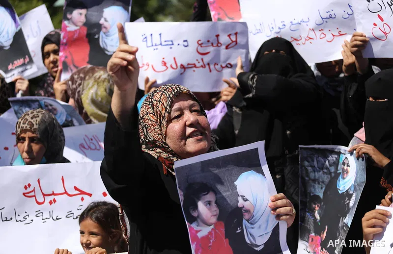 Palestinians hold banners during a protest due to prevent Ms. Jalila Dahlan from entering the Gaza Strip, in Gaza city, on Sept. 28, 2016. Photo by Mohammed Asad