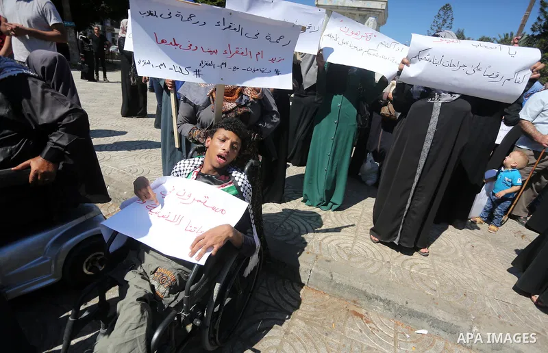 Palestinians hold banners during a protest due to prevent Ms. Jalila Dahlan from entering the Gaza Strip, in Gaza city, on Sept. 28, 2016. Photo by Mohammed Asad