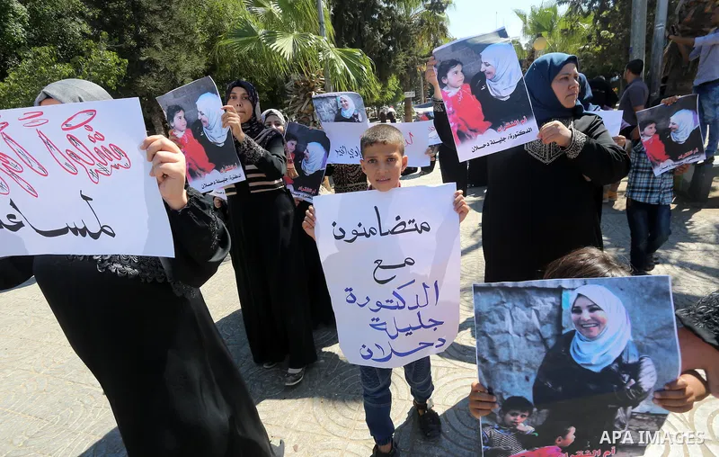 Palestinians hold banners during a protest due to prevent Ms. Jalila Dahlan from entering the Gaza Strip, in Gaza city, on Sept. 28, 2016. Photo by Mohammed Asad