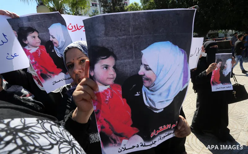 Palestinians hold banners during a protest due to prevent Ms. Jalila Dahlan from entering the Gaza Strip, in Gaza city, on Sept. 28, 2016. Photo by Mohammed Asad