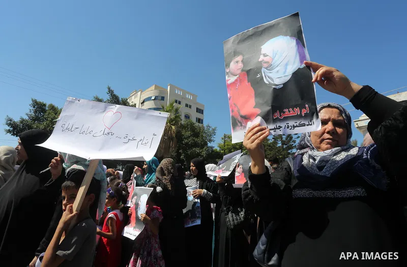Palestinians hold banners during a protest due to prevent Ms. Jalila Dahlan from entering the Gaza Strip, in Gaza city, on Sept. 28, 2016. Photo by Mohammed Asad