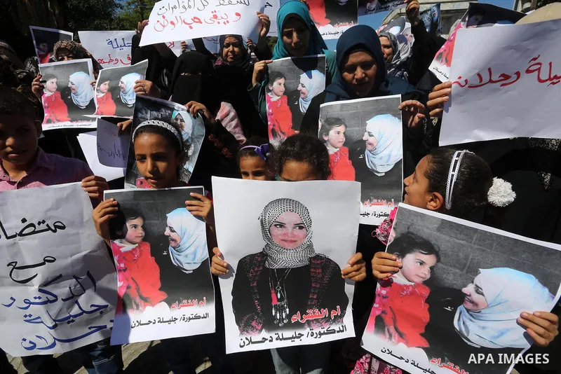 Palestinians hold banners during a protest due to prevent Ms. Jalila Dahlan from entering the Gaza Strip, in Gaza city, on Sept. 28, 2016. Photo by Mohammed Asad