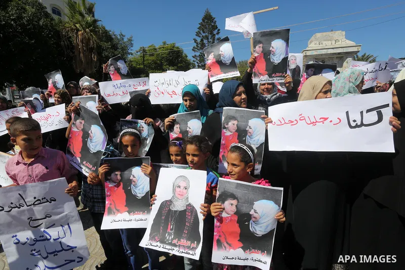 Palestinians hold banners during a protest due to prevent Ms. Jalila Dahlan from entering the Gaza Strip, in Gaza city, on Sept. 28, 2016. Photo by Mohammed Asad
