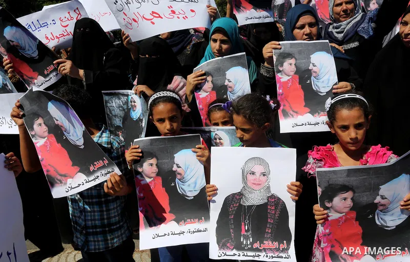 Palestinians hold banners during a protest due to prevent Ms. Jalila Dahlan from entering the Gaza Strip, in Gaza city, on Sept. 28, 2016. Photo by Mohammed Asad