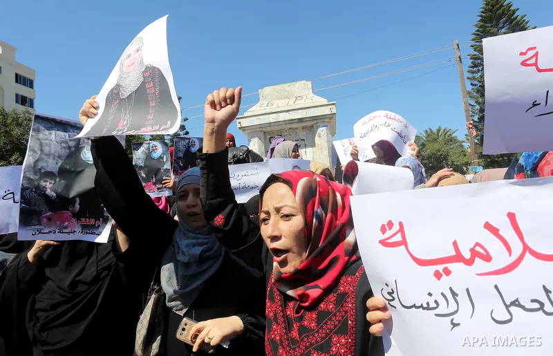 Palestinians hold banners during a protest due to prevent Ms. Jalila Dahlan from entering the Gaza Strip, in Gaza city, on Sept. 28, 2016. Photo by Mohammed Asad