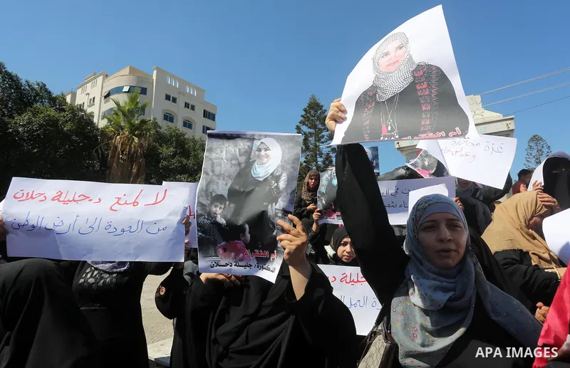 Palestinians hold banners during a protest due to prevent Ms. Jalila Dahlan from entering the Gaza Strip, in Gaza city, on Sept. 28, 2016. Photo by Mohammed Asad