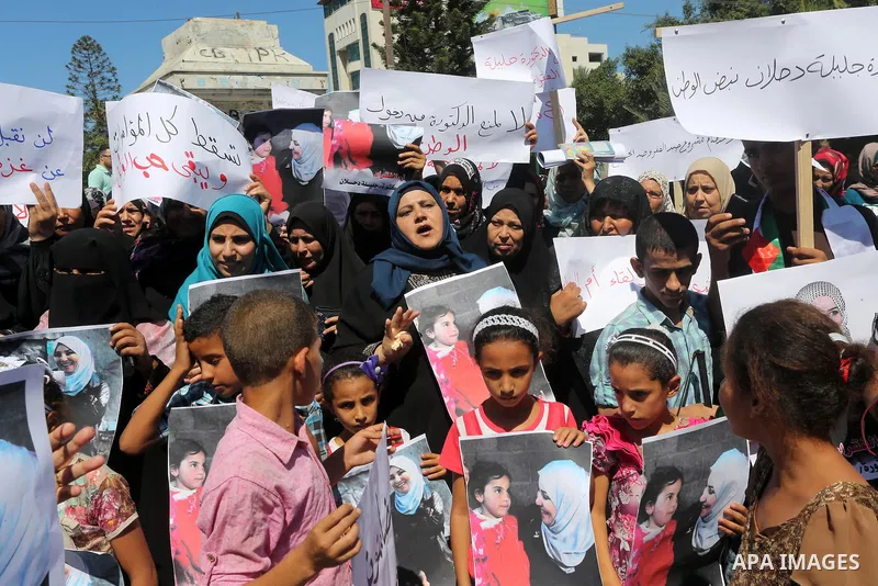 Palestinians hold banners during a protest due to prevent Ms. Jalila Dahlan from entering the Gaza Strip, in Gaza city, on Sept. 28, 2016. Photo by Mohammed Asad