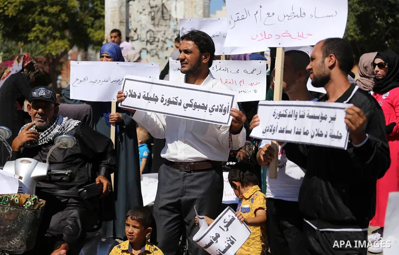 Palestinians hold banners during a protest due to prevent Ms. Jalila Dahlan from entering the Gaza Strip, in Gaza city, on Sept. 28, 2016. Photo by Mohammed Asad
