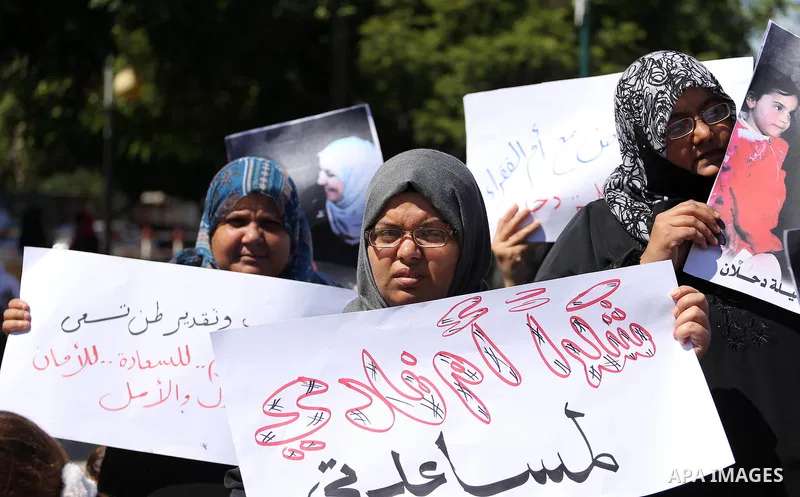 Palestinians hold banners during a protest due to prevent Ms. Jalila Dahlan from entering the Gaza Strip, in Gaza city, on Sept. 28, 2016. Photo by Mohammed Asad