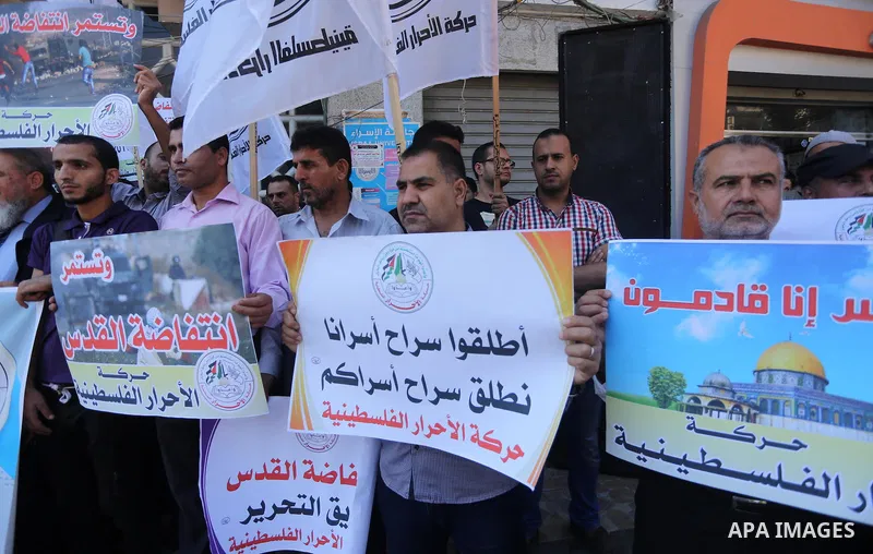 Palestinians hold banners during a protest to show solidarity with Prisoner in Israeli jails and Palestinians in Jerusalem, in Gaza city, on Sept. 28, 2016. Photo by Mohammed Asad