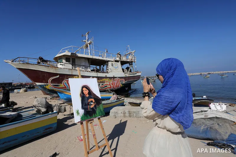A Palestinian artist paints artwork during a protest supporting of a Gaza-bound flotilla of international activists attempting to break the Gaza blockade, at Gaza seaport on September 29, 2016. Photo by Mohammed Asad
