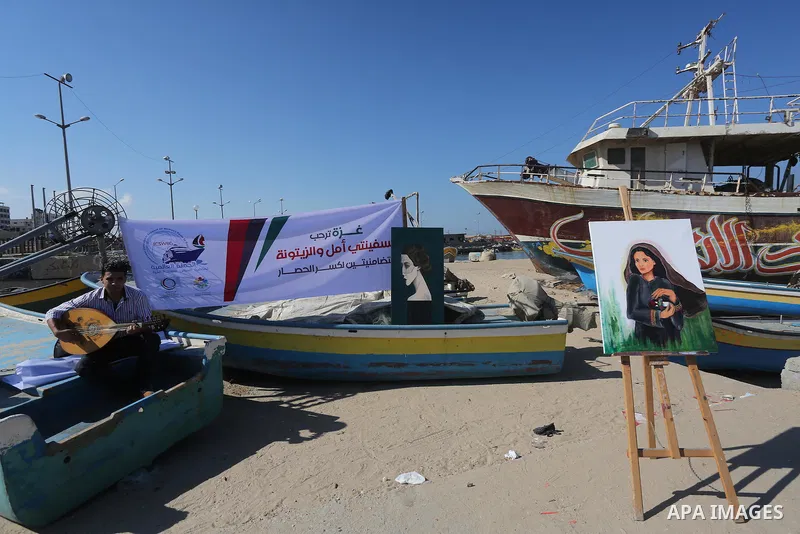Palestinian artists paint artwork during a protest supporting of a Gaza-bound flotilla of international activists attempting to break the Gaza blockade, at Gaza seaport on September 29, 2016. Photo by Mohammed Asad