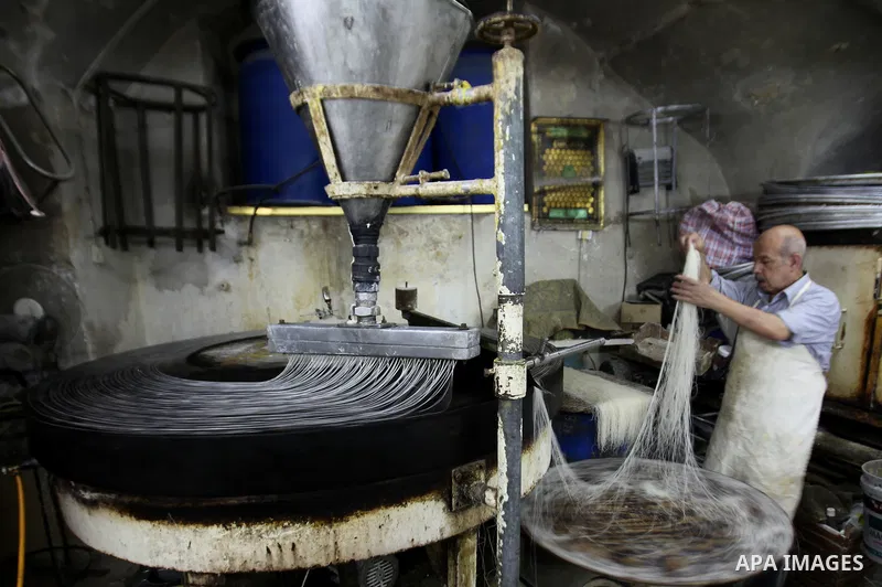 Palestinian Belal al-Zaqa, 64, prepares Kunafa, a traditional and favorite local sweet at his shop, in the West Bank city of Nablus on Sep. 29, 2016. Photo by Nedal Eshtayah