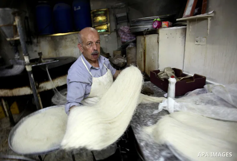 Palestinian Belal al-Zaqa, 64, prepares Kunafa, a traditional and favorite local sweet at his shop, in the West Bank city of Nablus on Sep. 29, 2016. Photo by Nedal Eshtayah