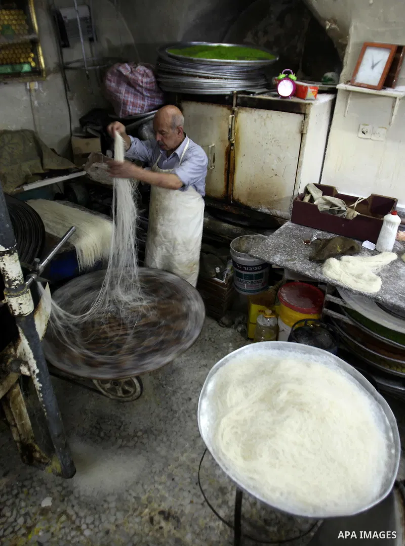 Palestinian Belal al-Zaqa, 64, prepares Kunafa, a traditional and favorite local sweet at his shop, in the West Bank city of Nablus on Sep. 29, 2016. Photo by Nedal Eshtayah