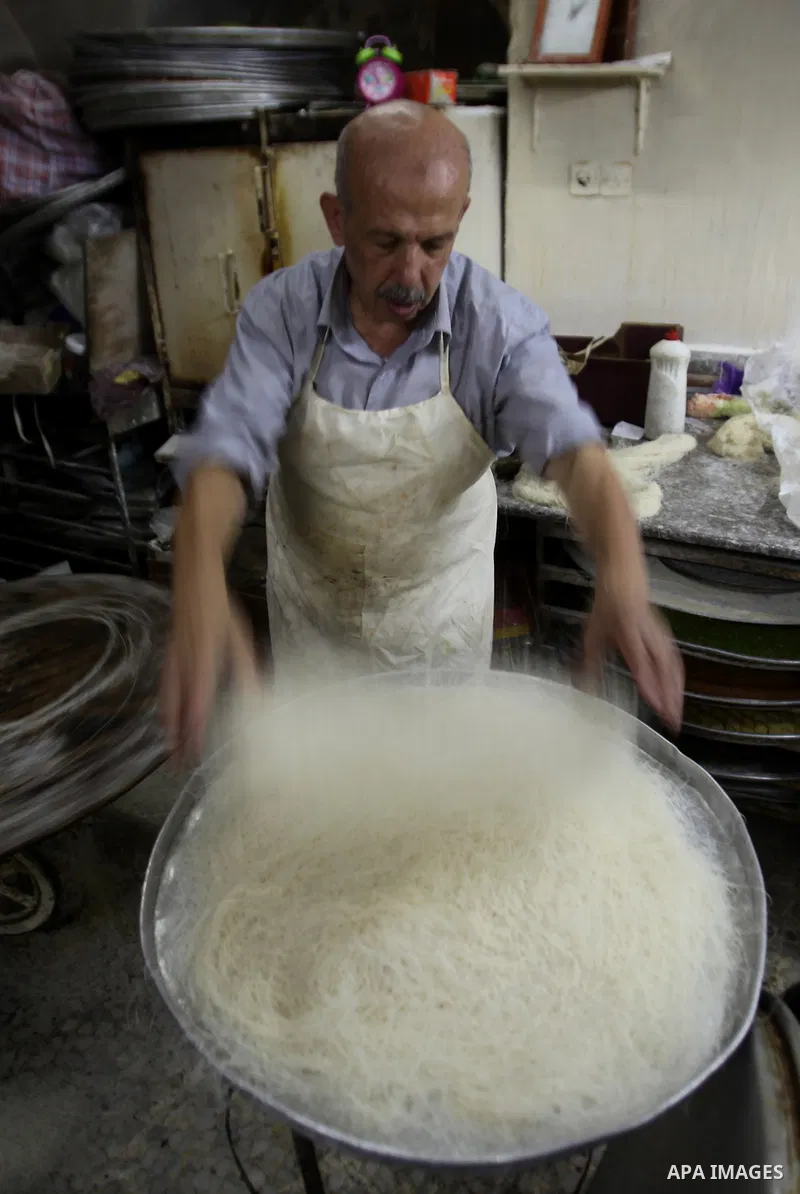 Palestinian Belal al-Zaqa, 64, prepares Kunafa, a traditional and favorite local sweet at his shop, in the West Bank city of Nablus on Sep. 29, 2016. Photo by Nedal Eshtayah