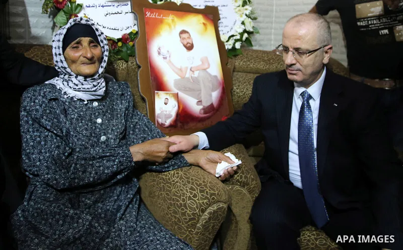 Palestinian Prime Minister Rami Hamdallah visits the mother of Yassir Hamduni who died in Israeli custody following a fatal stroke, in the West Bank city of Jenin on Sep. 29, 2016. Photo by Prime Minister Office