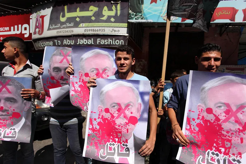 Palestinians hold crossed posters of former Israeli President Shimon Peres, U.S. President Barack Obama and Israeli Prime Minister Benjamin Netanyahu before burning them during a rally following Friday prayers in Gaza Ci...