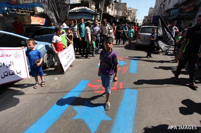 Palestinians step on Israeli flag during a rally following Friday prayers in Gaza City September 30, 2016. Photo by Ashraf Amra