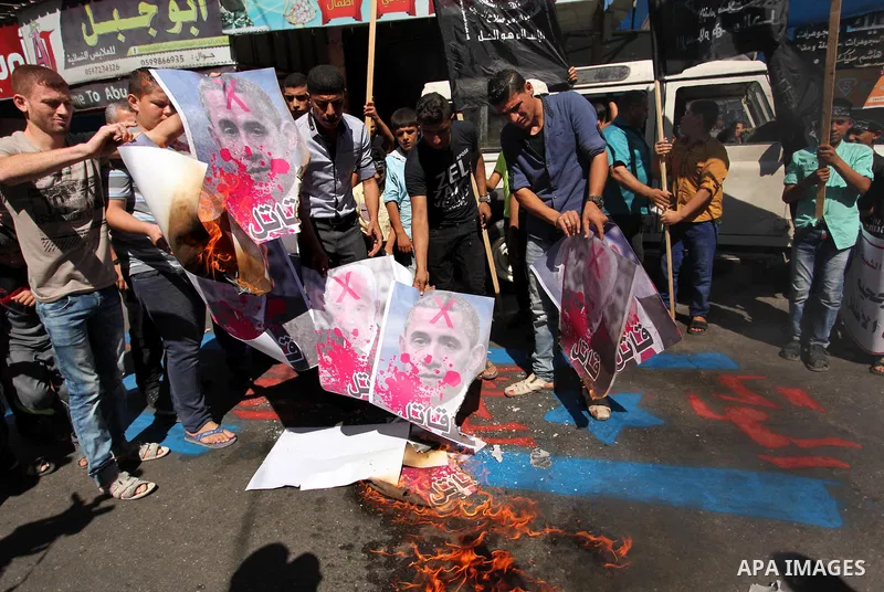 Palestinians burn crossed posters of former Israeli President Shimon Peres, U.S. President Barack Obama and Israeli Prime Minister Benjamin Netanyahu during a rally following Friday prayers in Gaza City September 30, 201...