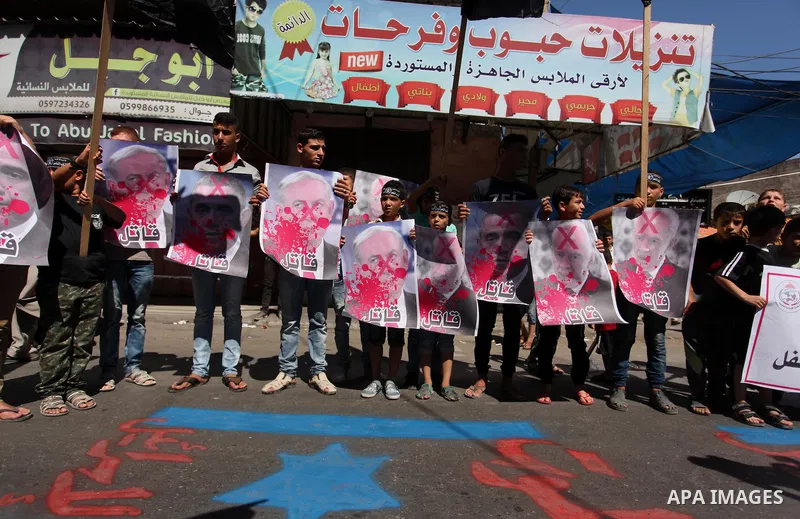 Palestinians hold crossed posters of former Israeli President Shimon Peres, U.S. President Barack Obama and Israeli Prime Minister Benjamin Netanyahu before burning them during a rally following Friday prayers in Gaza Ci...