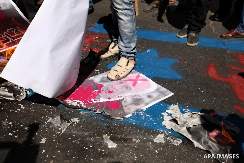 A Palestinian steps on a crossed poster of former Israeli President Shimon Peres, reading "Murderer", during a rally following Friday prayers in Gaza City September 30, 2016. Photo by Ashraf Amra