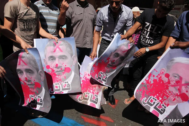 Palestinians burn crossed posters of former Israeli President Shimon Peres, U.S. President Barack Obama and Israeli Prime Minister Benjamin Netanyahu during a rally following Friday prayers in Gaza City September 30, 201...