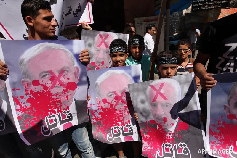 Palestinians hold crossed posters of former Israeli President Shimon Peres, U.S. President Barack Obama and Israeli Prime Minister Benjamin Netanyahu before burning them during a rally following Friday prayers in Gaza Ci...