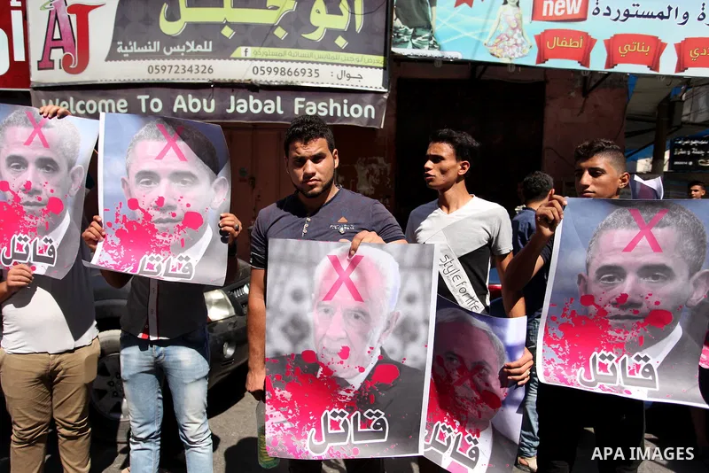 Palestinians hold crossed posters of former Israeli President Shimon Peres, U.S. President Barack Obama and Israeli Prime Minister Benjamin Netanyahu before burning them during a rally following Friday prayers in Gaza Ci...