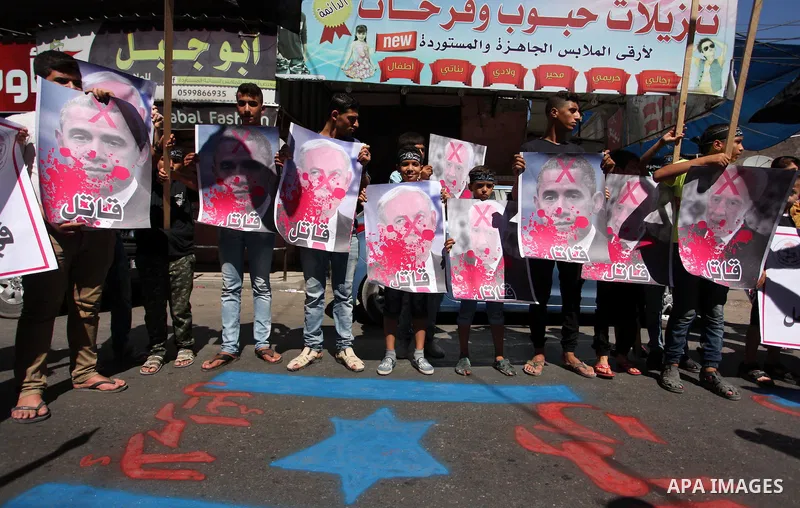 Palestinians hold crossed posters of former Israeli President Shimon Peres, U.S. President Barack Obama and Israeli Prime Minister Benjamin Netanyahu before burning them during a rally following Friday prayers in Gaza Ci...