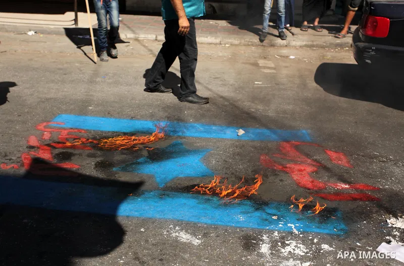Palestinians burn crossed posters of former Israeli President Shimon Peres, U.S. President Barack Obama and Israeli Prime Minister Benjamin Netanyahu during a rally following Friday prayers in Gaza City September 30, 201...