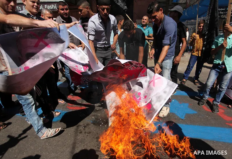 Palestinians burn crossed posters of former Israeli President Shimon Peres, U.S. President Barack Obama and Israeli Prime Minister Benjamin Netanyahu during a rally following Friday prayers in Gaza City September 30, 201...