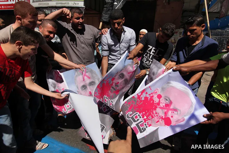 Palestinians burn crossed posters of former Israeli President Shimon Peres, U.S. President Barack Obama and Israeli Prime Minister Benjamin Netanyahu during a rally following Friday prayers in Gaza City September 30, 201...