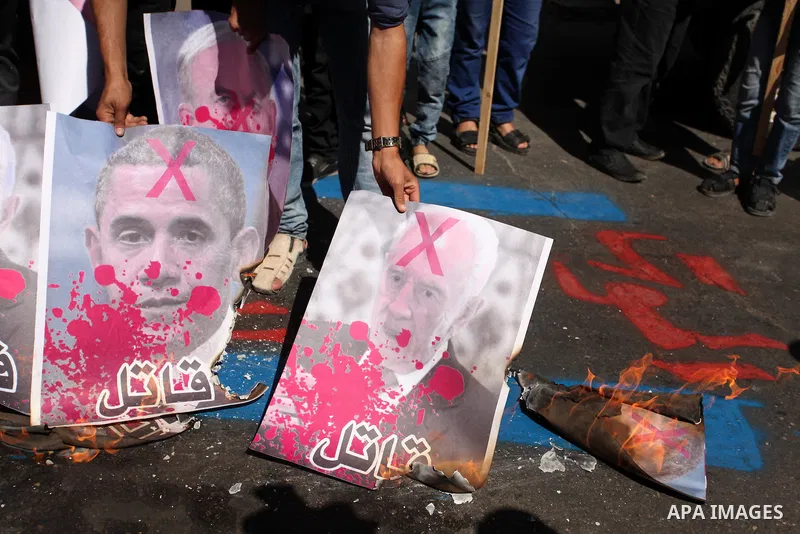 Palestinians burn crossed posters of former Israeli President Shimon Peres, U.S. President Barack Obama and Israeli Prime Minister Benjamin Netanyahu during a rally following Friday prayers in Gaza City September 30, 201...