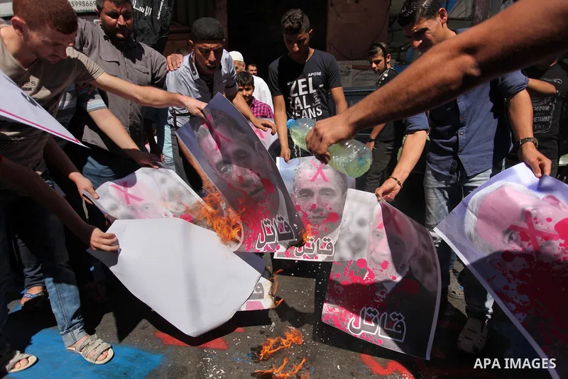 Palestinians burn crossed posters of former Israeli President Shimon Peres, U.S. President Barack Obama and Israeli Prime Minister Benjamin Netanyahu during a rally following Friday prayers in Gaza City September 30, 201...