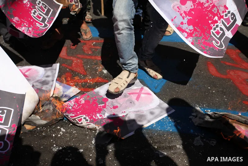 A Palestinian steps on a crossed poster of former Israeli President Shimon Peres, reading "Murderer", during a rally following Friday prayers in Gaza City September 30, 2016. Photo by Ashraf Amra