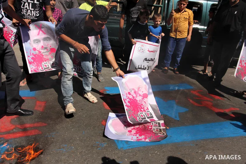 Palestinians burn crossed posters of former Israeli President Shimon Peres, U.S. President Barack Obama and Israeli Prime Minister Benjamin Netanyahu during a rally following Friday prayers in Gaza City September 30, 201...