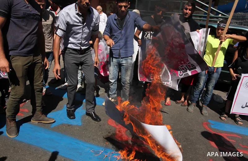 Palestinians burn crossed posters of former Israeli President Shimon Peres, U.S. President Barack Obama and Israeli Prime Minister Benjamin Netanyahu during a rally following Friday prayers in Gaza City September 30, 201...