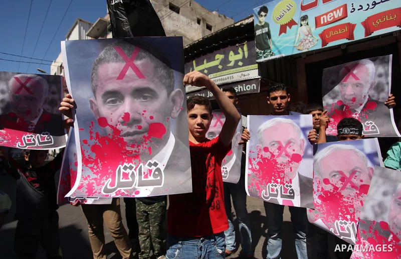 Palestinians hold crossed posters of former Israeli President Shimon Peres, U.S. President Barack Obama and Israeli Prime Minister Benjamin Netanyahu before burning them during a rally following Friday prayers in Gaza Ci...