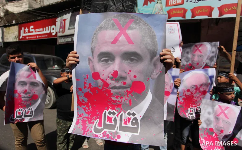 Palestinians hold crossed posters of former Israeli President Shimon Peres, U.S. President Barack Obama and Israeli Prime Minister Benjamin Netanyahu before burning them during a rally following Friday prayers in Gaza Ci...