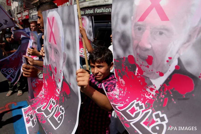 Palestinians hold crossed posters of former Israeli President Shimon Peres, U.S. President Barack Obama and Israeli Prime Minister Benjamin Netanyahu before burning them during a rally following Friday prayers in Gaza Ci...