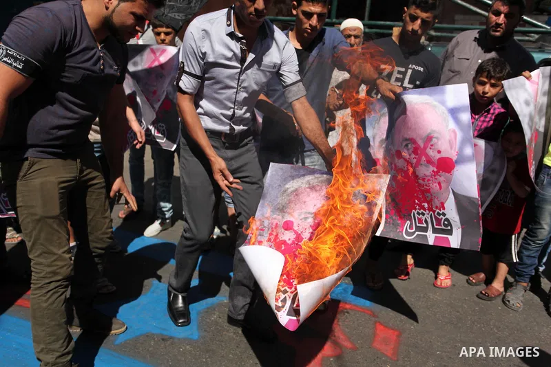 Palestinians burn crossed posters of former Israeli President Shimon Peres, U.S. President Barack Obama and Israeli Prime Minister Benjamin Netanyahu during a rally following Friday prayers in Gaza City September 30, 201...