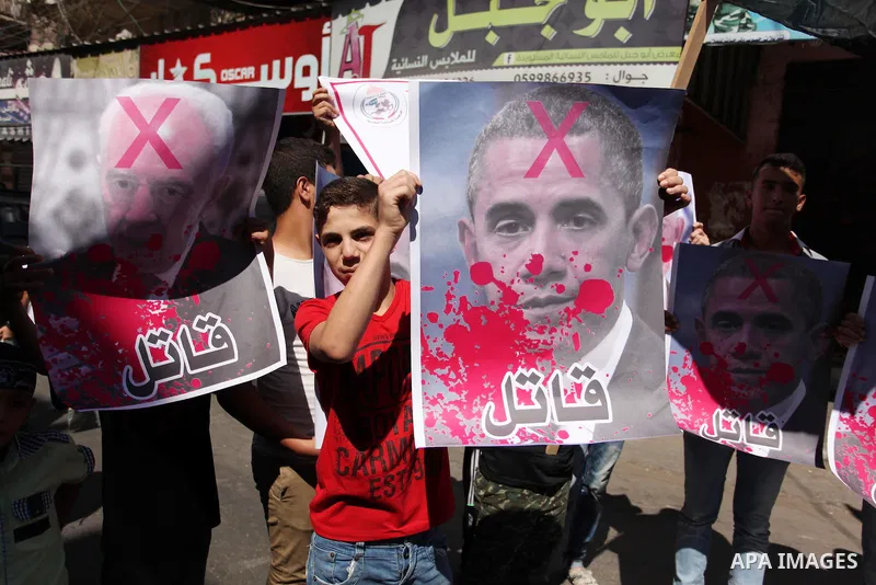 Palestinians hold crossed posters of former Israeli President Shimon Peres, U.S. President Barack Obama and Israeli Prime Minister Benjamin Netanyahu before burning them during a rally following Friday prayers in Gaza Ci...