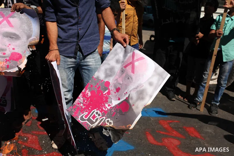 Palestinians burn crossed posters of former Israeli President Shimon Peres, U.S. President Barack Obama and Israeli Prime Minister Benjamin Netanyahu during a rally following Friday prayers in Gaza City September 30, 201...